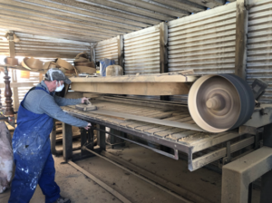 Tony Kilmister from Kilmister Furniture Restoration using a large belt sander to sand back wooden furniture.