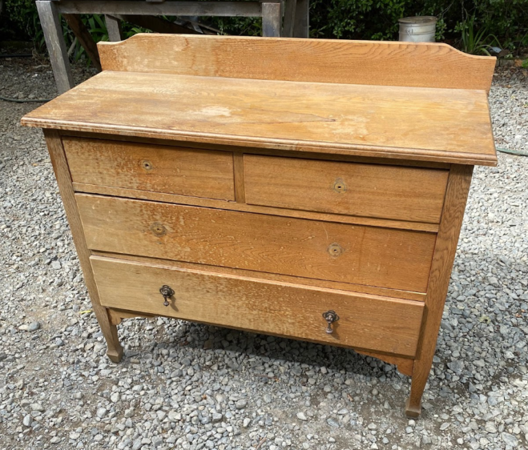 Wooden chest of drawers showcases extensive water damage.