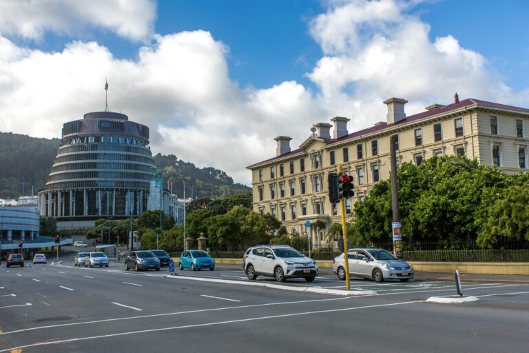 Cars driving on a road in Wellington with the Beehive building in the background.