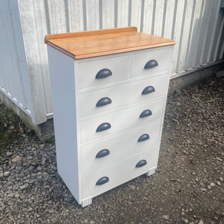 Chest of drawers that has been painted with white paint.